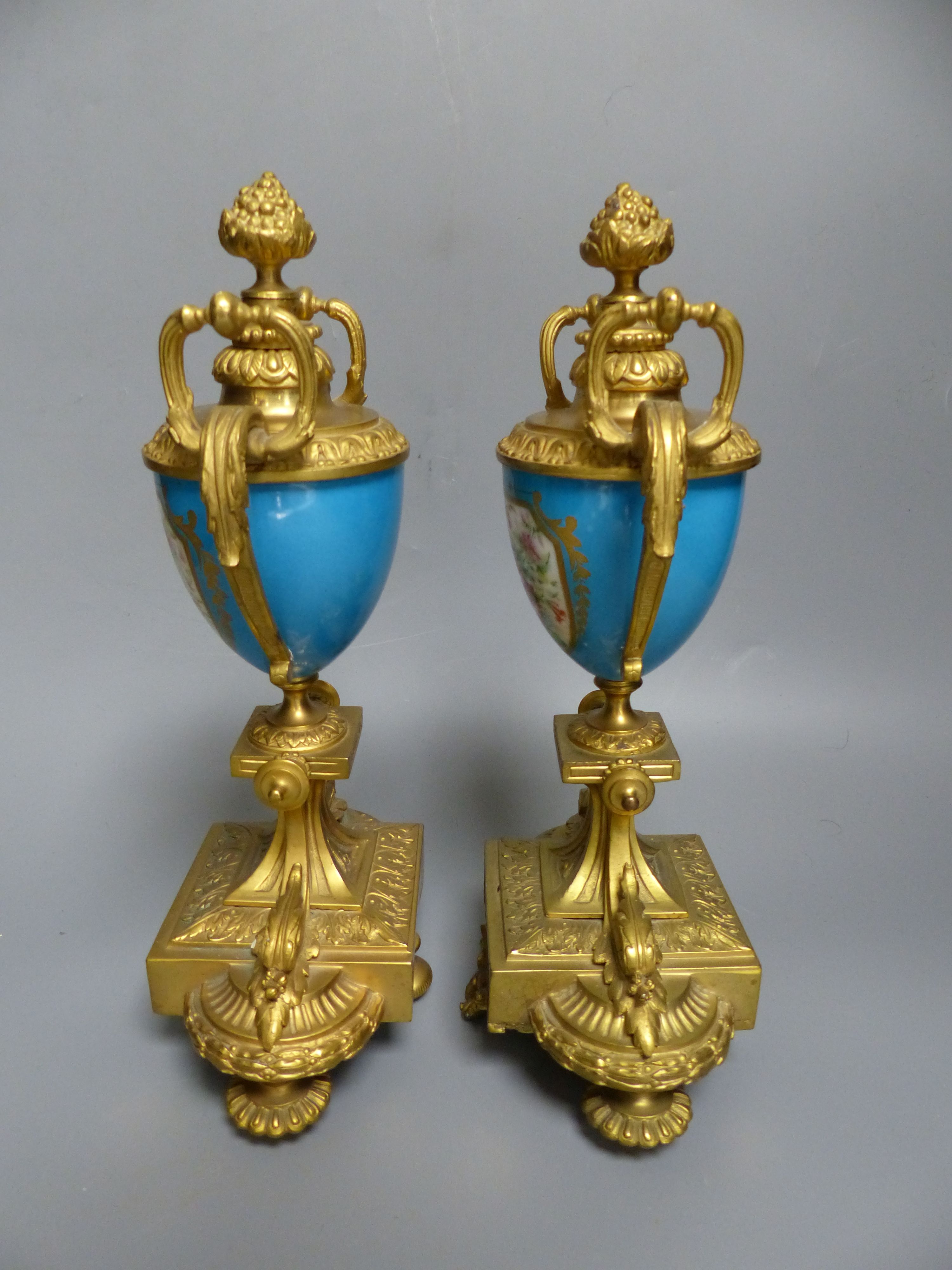 A pair of 19th century French ormolu and Sevres style porcelain urns, decorated with flowers and landscapes, height 26.5cm